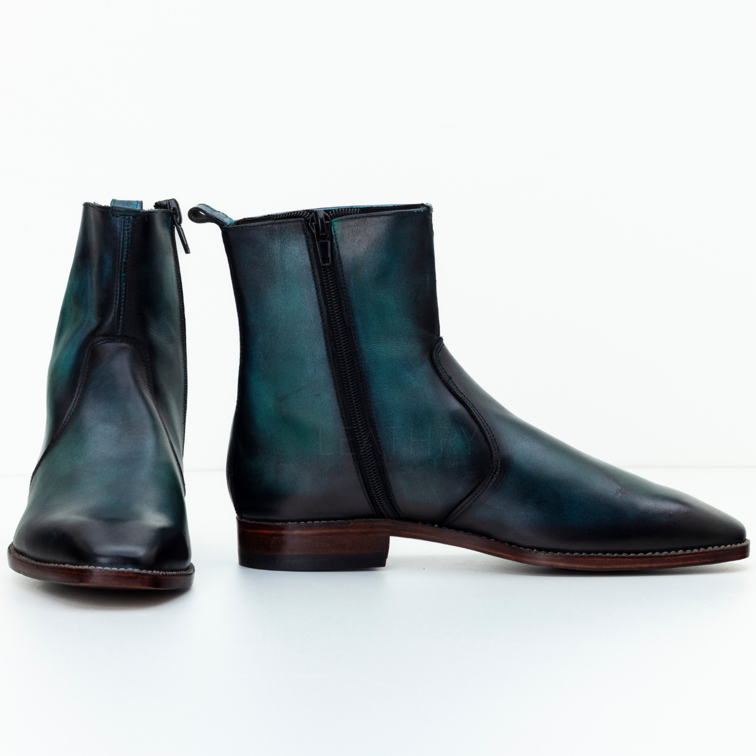 Pair of black leather ankle boots on a white background