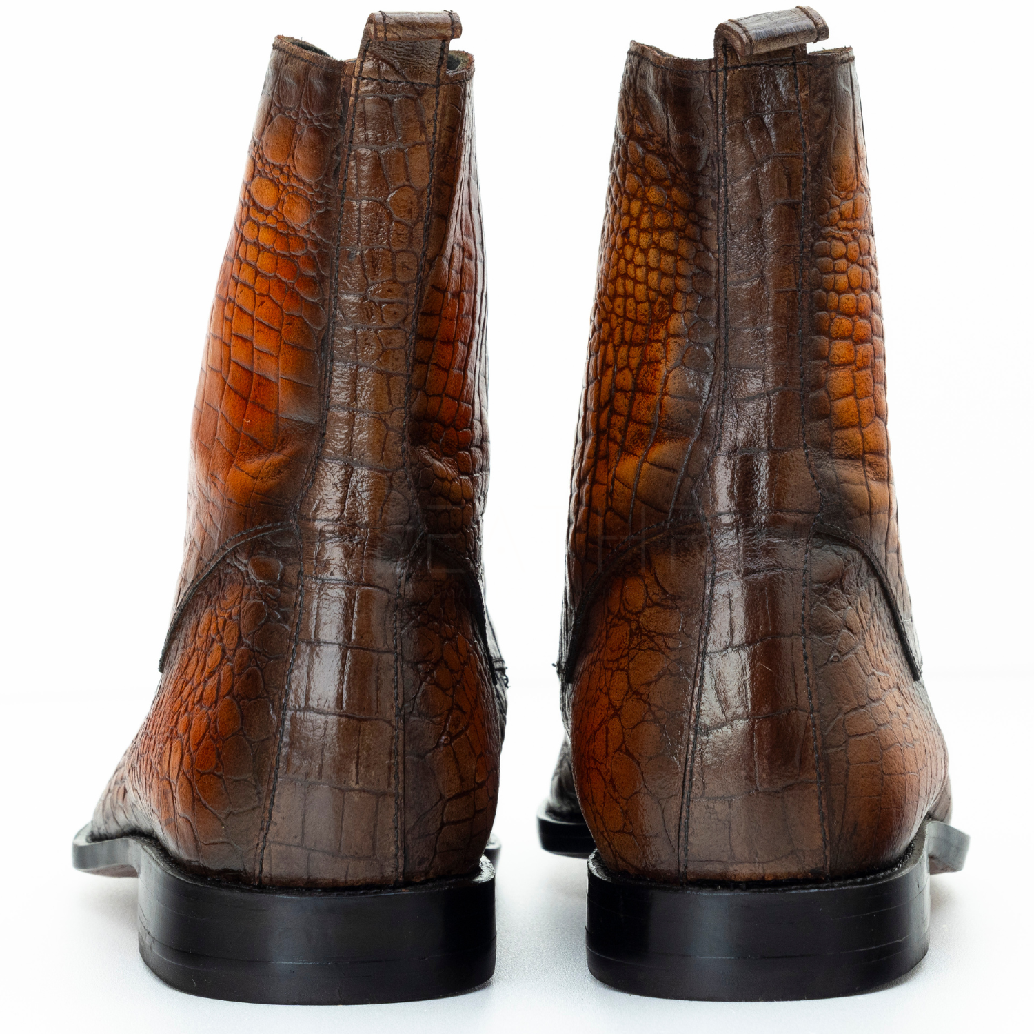 Brown crocodile skin boots on a white background