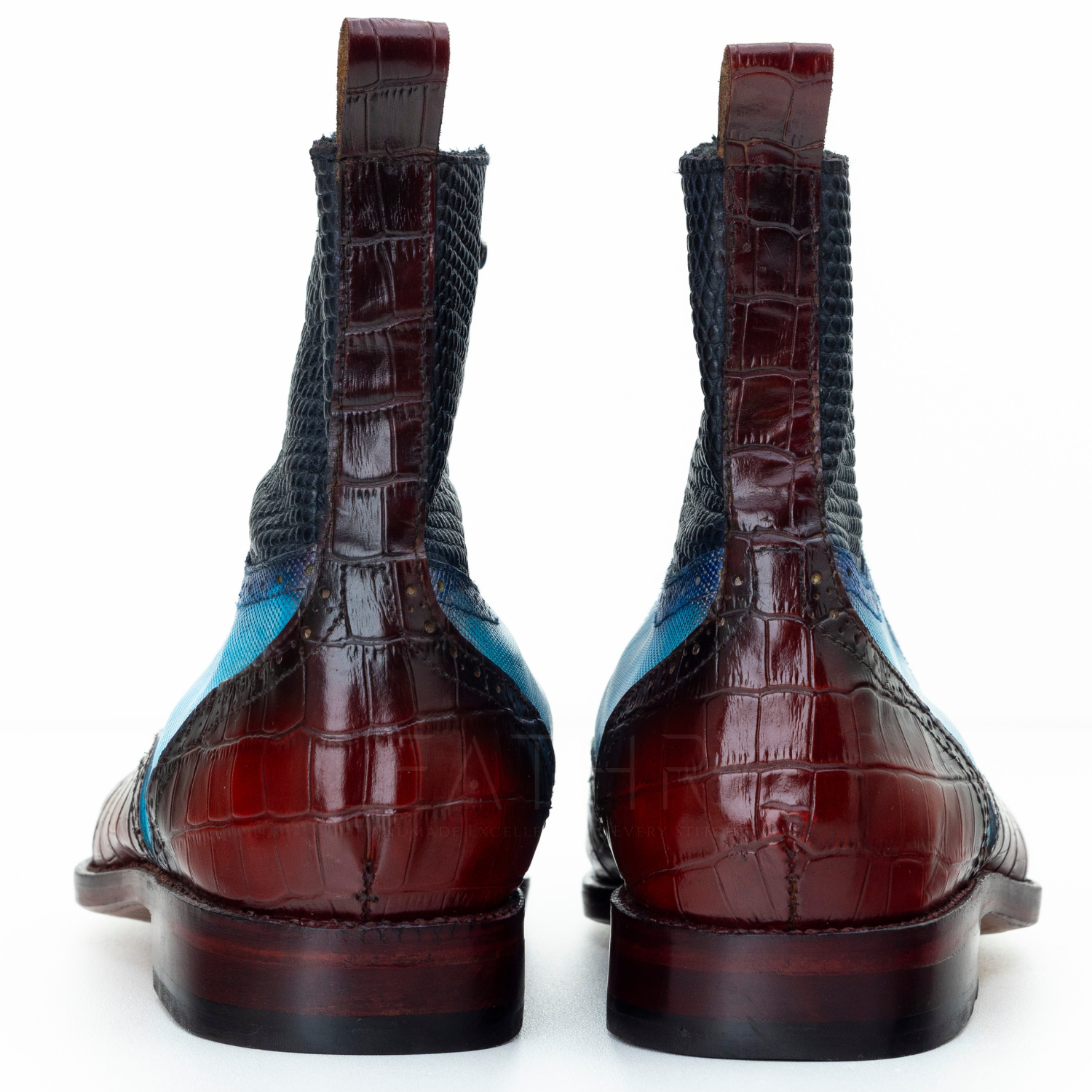 Pair of brown crocodile skin boots with blue lining on a white background