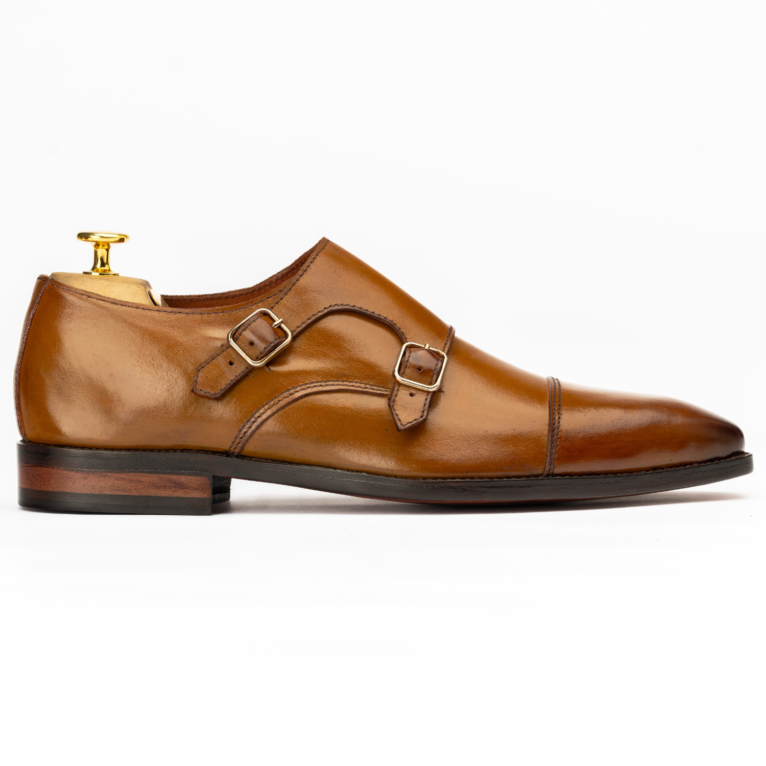 Brown leather shoe with gold buckle on a white background