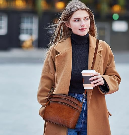 Woman in a brown coat holding a coffee cup on a city street