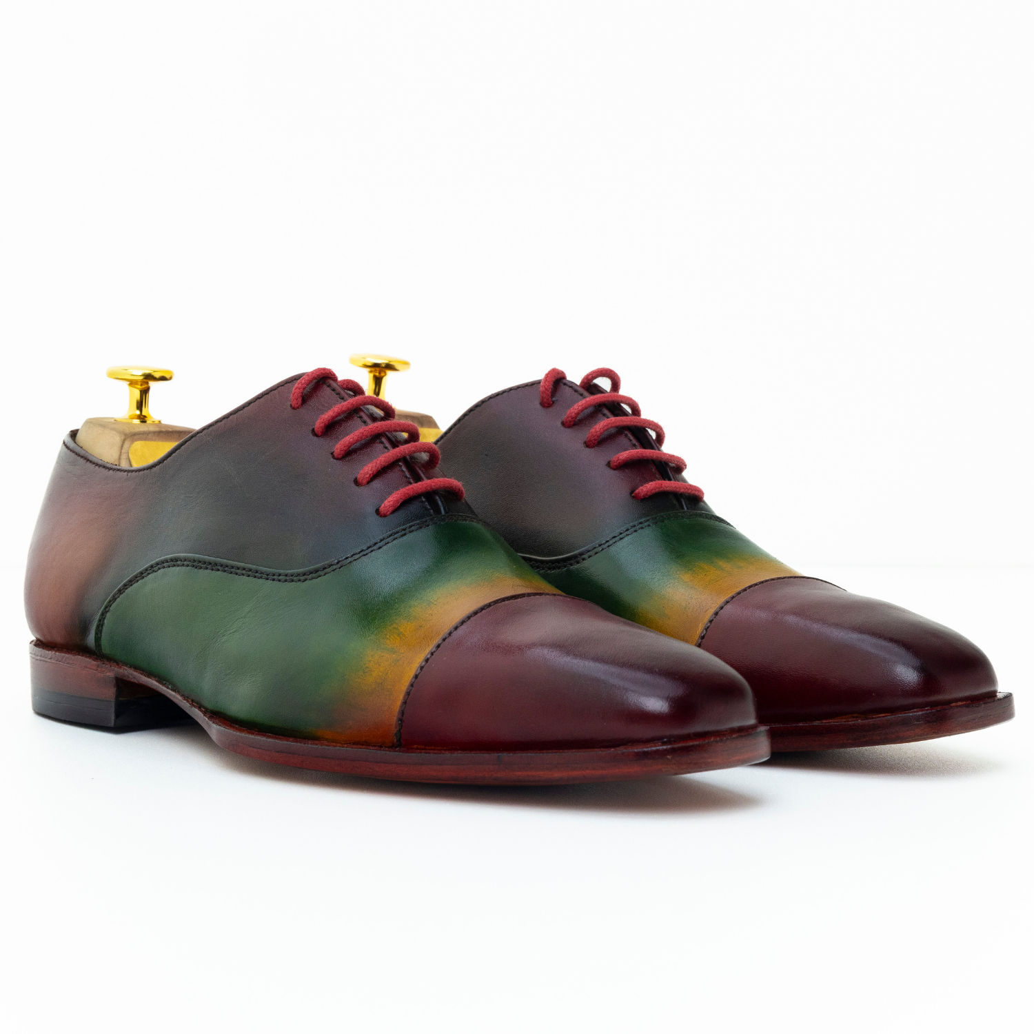 Multicolored dress shoes with red laces on a white background