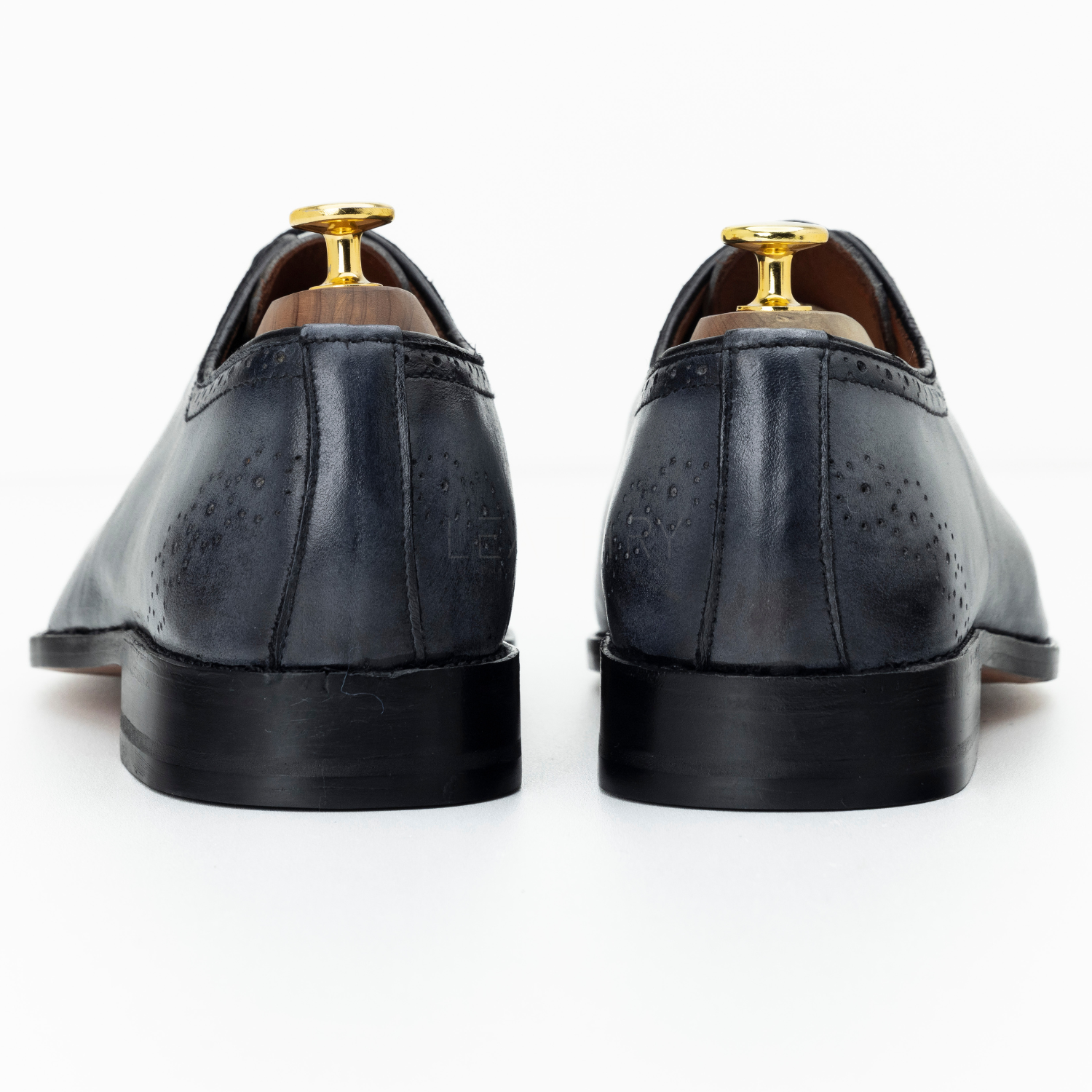 Pair of black leather dress shoes on a white background