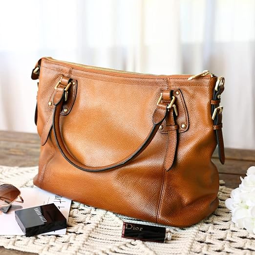 Brown leather handbag on a textured surface with a blurred background