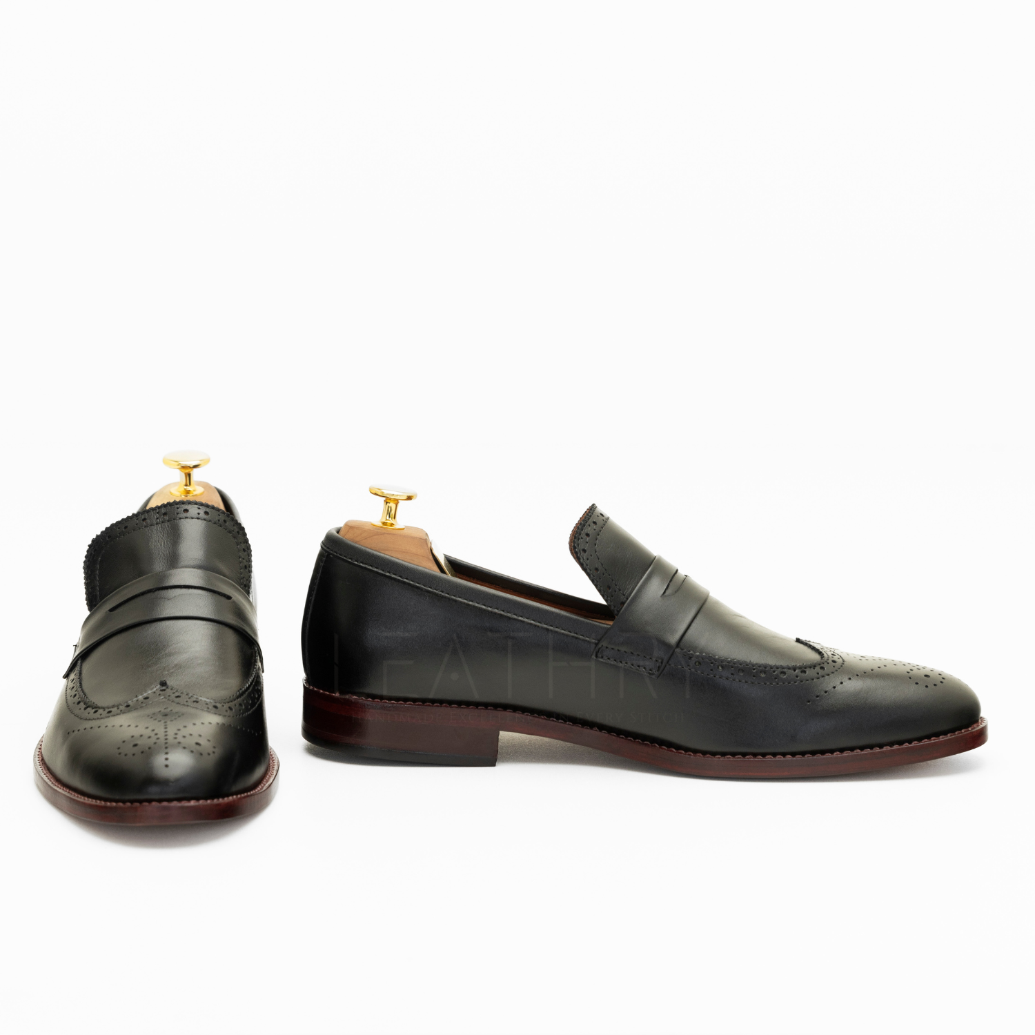 Pair of black leather loafers on a white background
