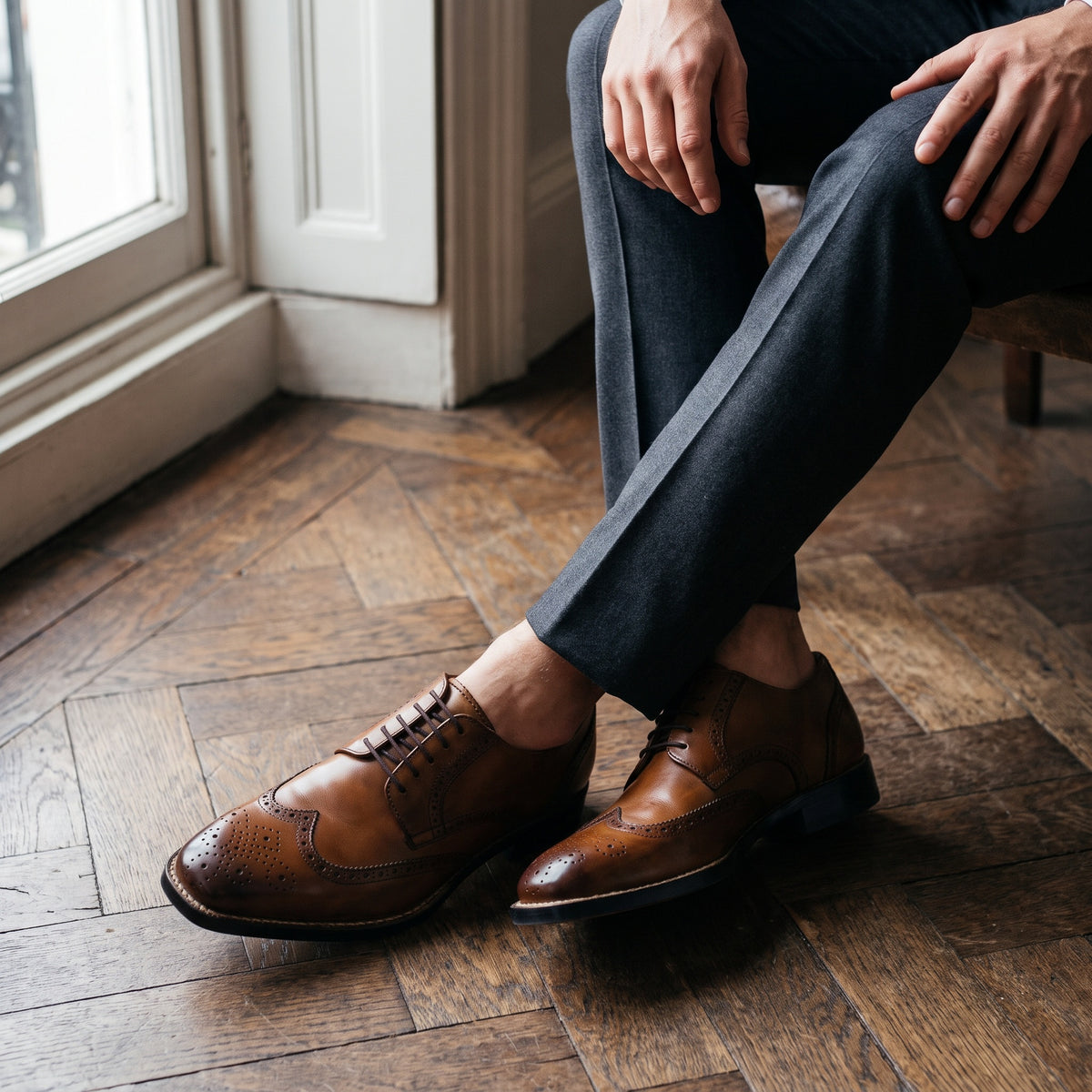 The Ashcroft men's wingtip Derby shoe in tan brown calf leather with patina finish, styled editorial photo